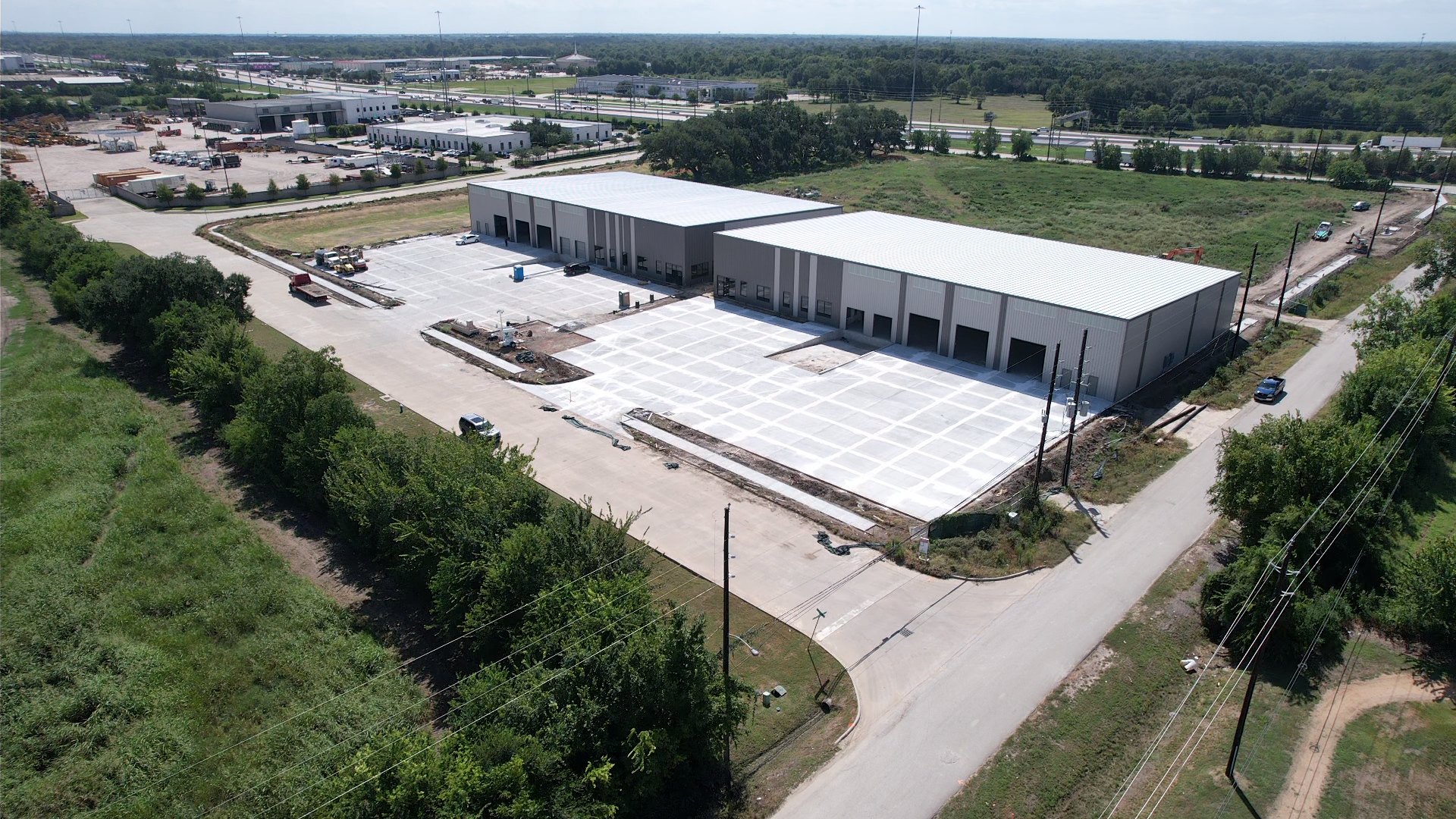 Aerial construction photo of the first two Chocolate Bayou buildings, roofs and wall panels complete with site paving underway